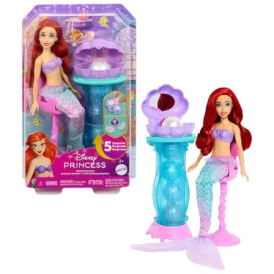 Abbildung von Mattel Disney Princess Spielzeuge, Schminkmuschel Meerjungfrau Arielle Modepuppe mit abnehmbarer Schwanzflosse, Schminktisch 5 wiederholbaren Pop up Überraschungen und Accessoires, JBF86